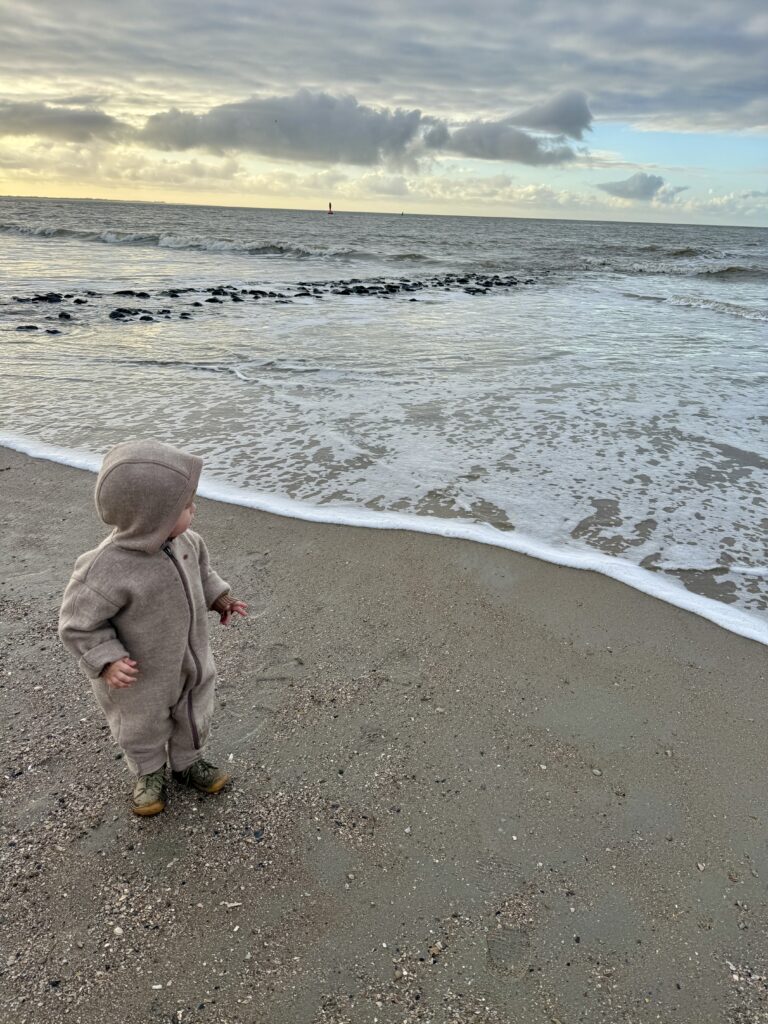 Kind spielt im Winter am Strand