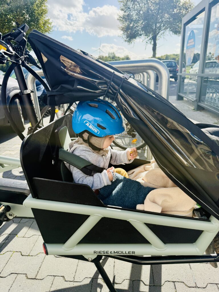 Familie fährt mit Lastenrad – sicherer Kindertransport im Cargo-Bike